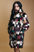 Model wearing a vintage 1970s patchwork rabbit fur coat in multicolour tones with a high collar