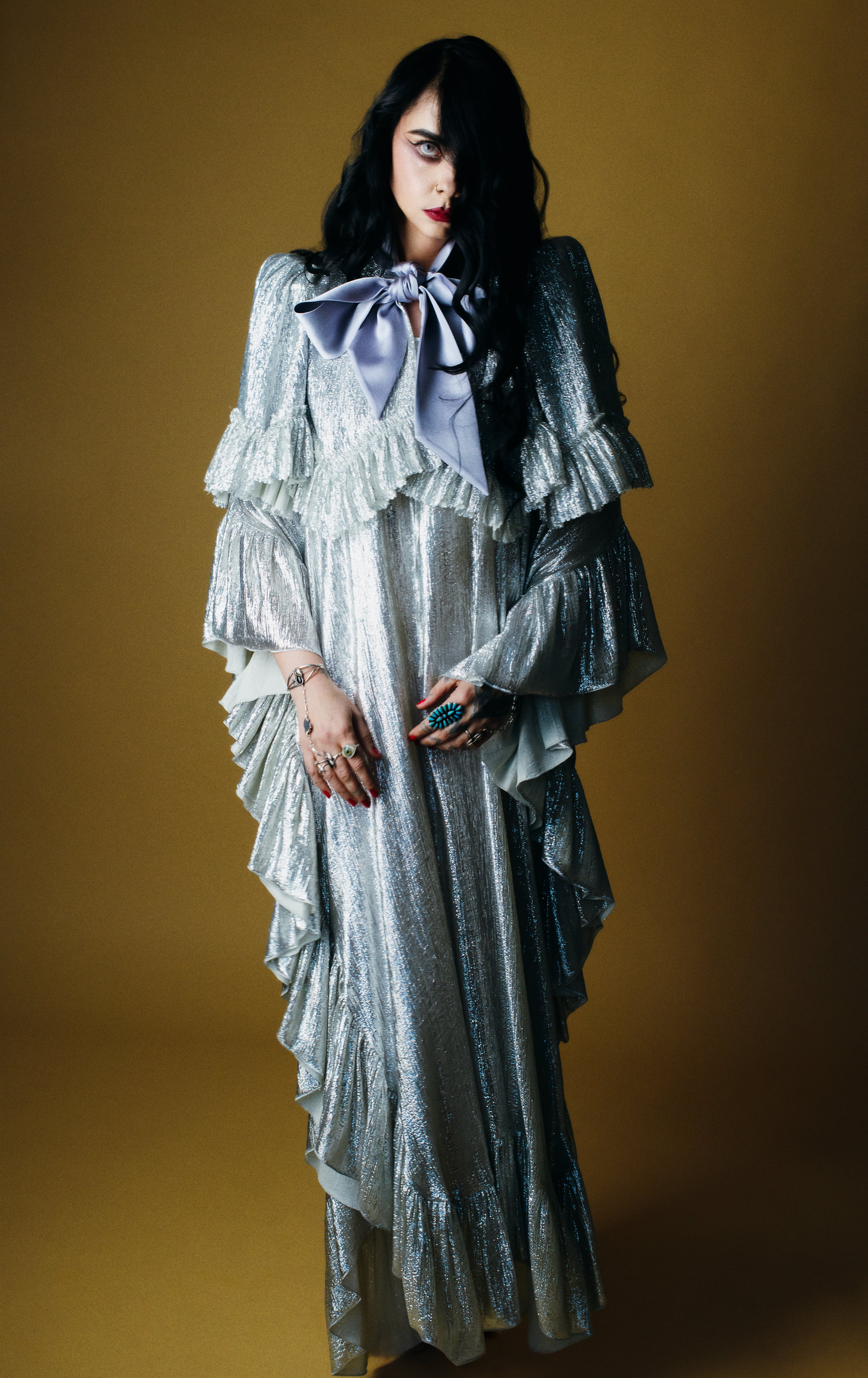 Women's silver metallic maxi dress with dramatic ruffle sleeves and oversized lavender bow